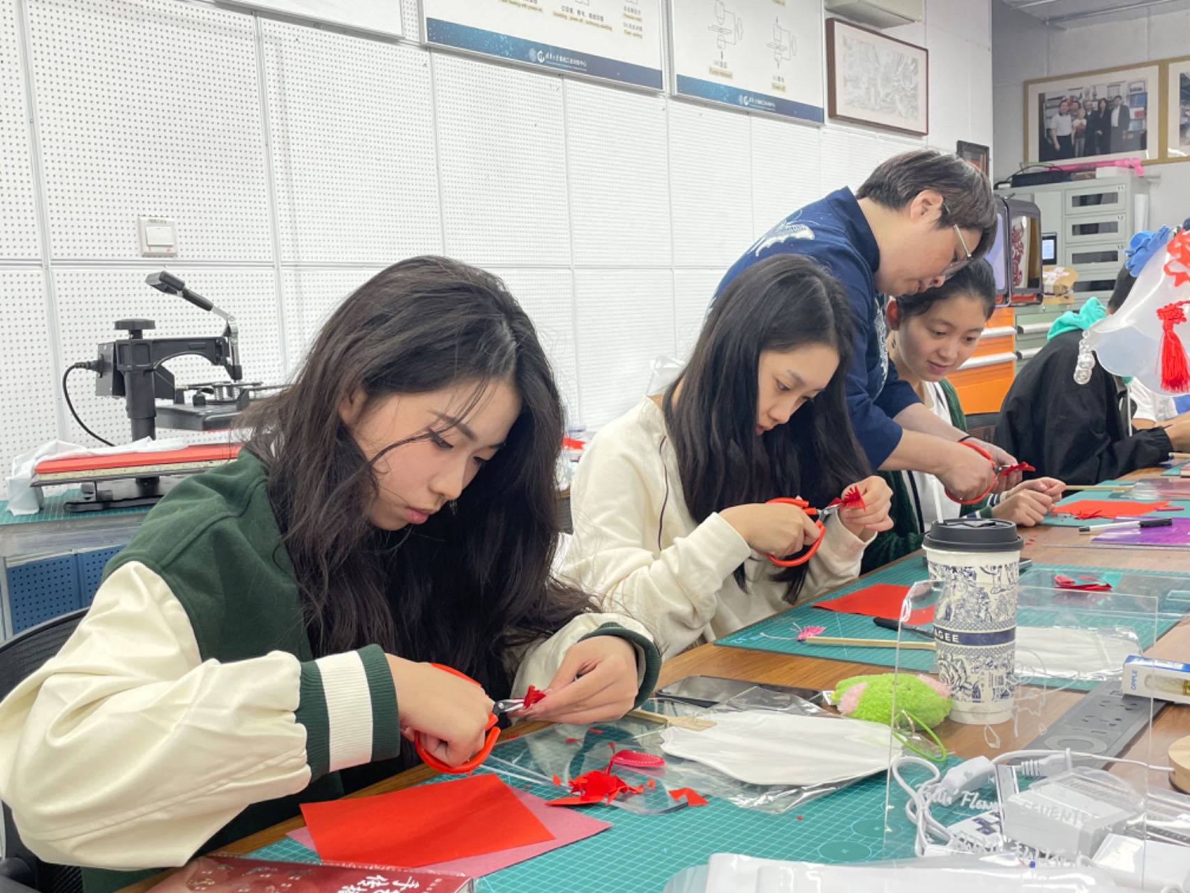 清华学生在“石头计划”李老师的指导下学习非遗剪纸